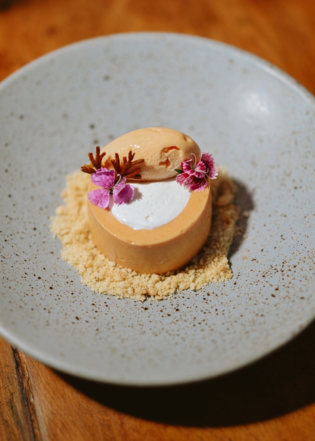 Plated dessert on crumble topped with edible flowers served at Viceroy Riviera Maya
