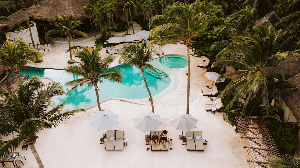 Aerial view of palm trees, sun loungers and umbrellas around the pools at Viceroy Riviera Maya