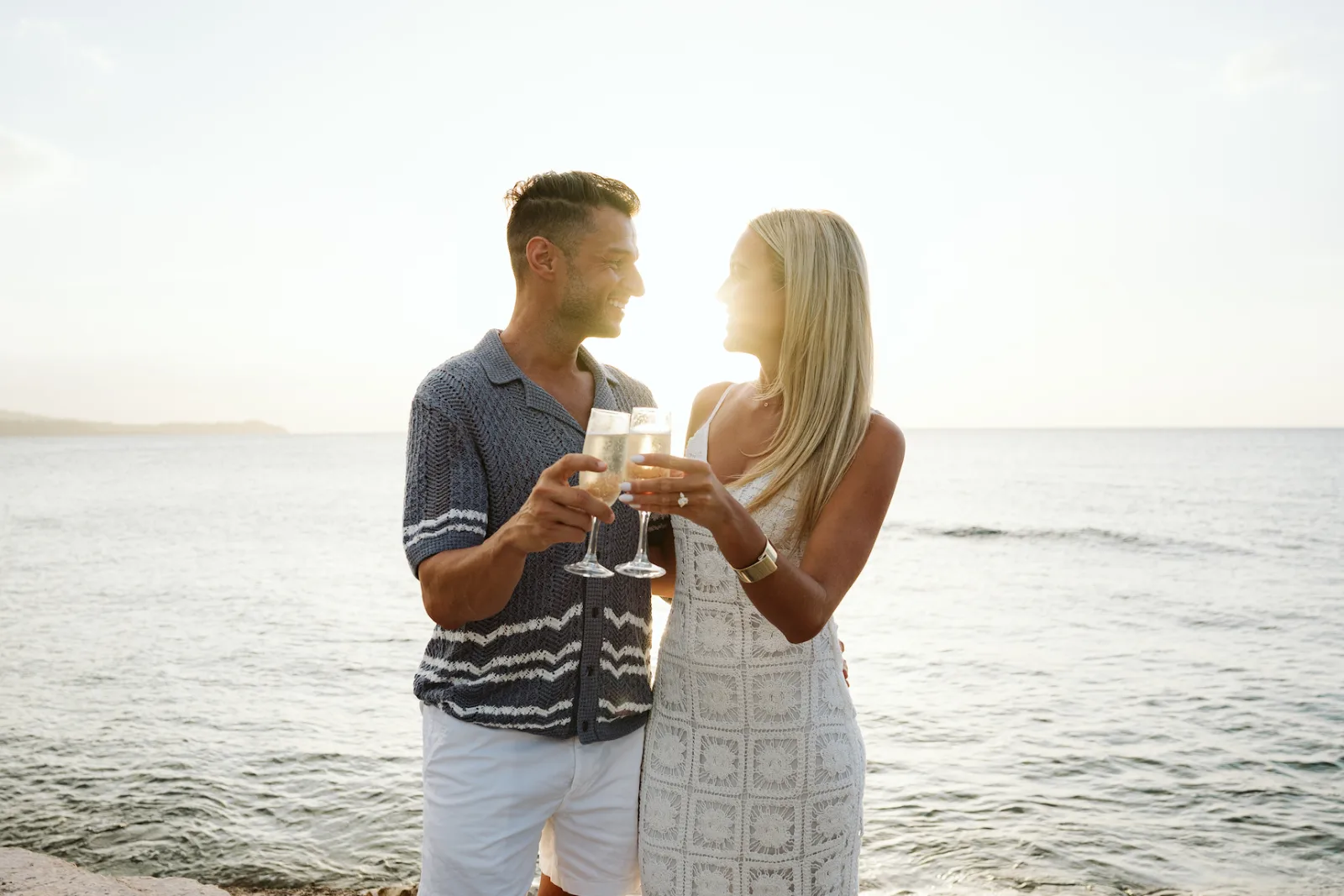 Honeymooners toast with champagne by the sea