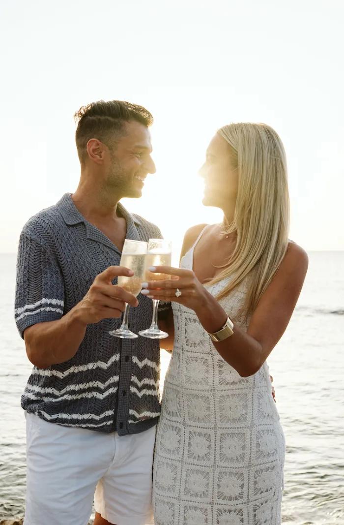 Honeymooners toast with champagne by the sea